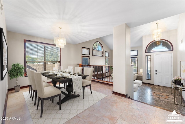 dining area with vaulted ceiling, a notable chandelier, and baseboards