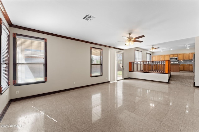 unfurnished living room with crown molding, visible vents, granite finish floor, a ceiling fan, and baseboards