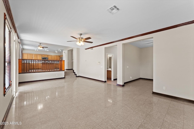 unfurnished living room with a ceiling fan, granite finish floor, visible vents, and baseboards