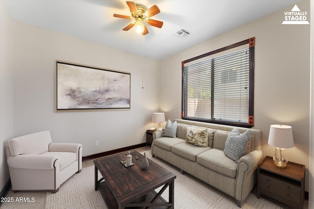 living area featuring visible vents, baseboards, and a ceiling fan