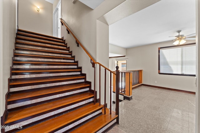 stairs with baseboards and a ceiling fan