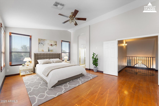 bedroom with baseboards, visible vents, multiple windows, and hardwood / wood-style flooring