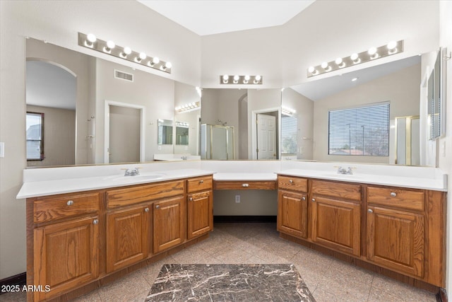 full bath featuring granite finish floor, two vanities, a sink, visible vents, and vaulted ceiling