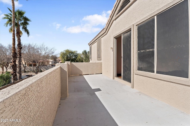 exterior space with a balcony and stucco siding