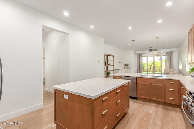 kitchen featuring light wood-type flooring, a center island, appliances with stainless steel finishes, and sink