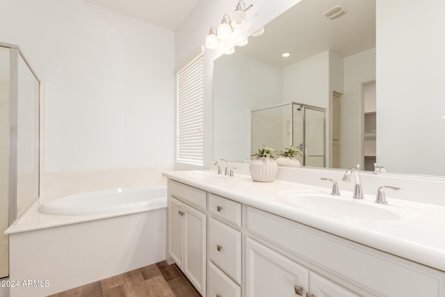 bathroom featuring wood-type flooring, vanity, and separate shower and tub