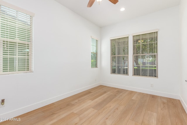 empty room featuring ceiling fan, light hardwood / wood-style floors, and a wealth of natural light