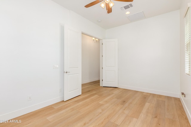 empty room with ceiling fan and light hardwood / wood-style flooring