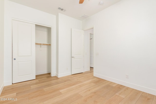 unfurnished bedroom with light hardwood / wood-style flooring, a closet, and ceiling fan