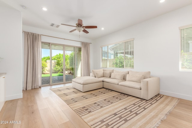 living room featuring light hardwood / wood-style flooring, ceiling fan, and a healthy amount of sunlight