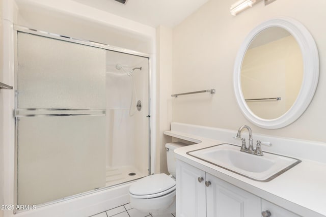 bathroom with tile patterned floors, vanity, an enclosed shower, and toilet