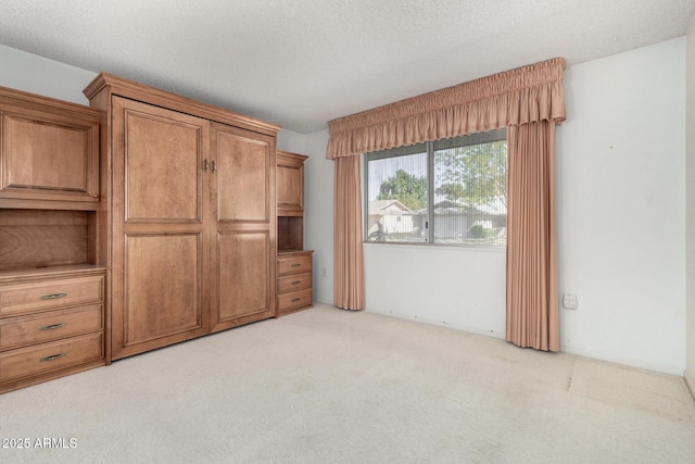 interior space featuring a textured ceiling and light colored carpet