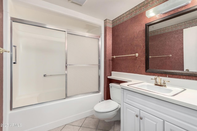 full bathroom with tile patterned floors, vanity, toilet, and bath / shower combo with glass door