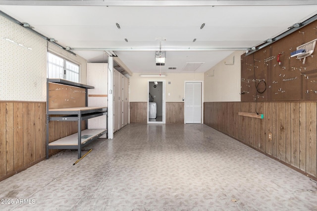 garage featuring a garage door opener and wood walls