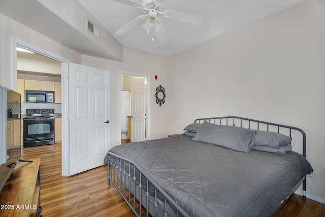 bedroom featuring visible vents, baseboards, ceiling fan, and wood finished floors