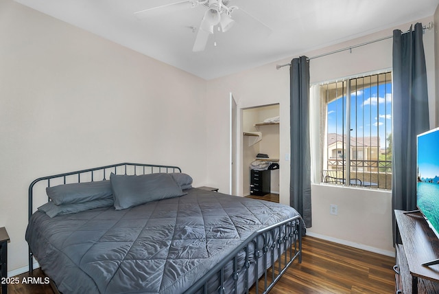 bedroom featuring baseboards, ceiling fan, wood finished floors, and a spacious closet