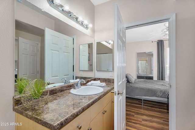 full bathroom with vanity, a ceiling fan, wood finished floors, and connected bathroom