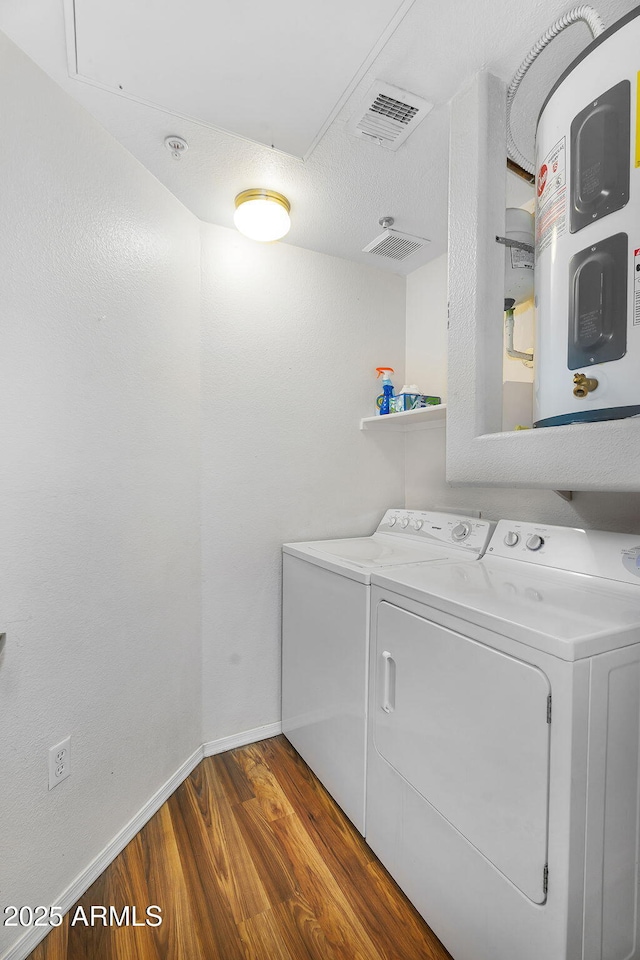 laundry area with laundry area, separate washer and dryer, baseboards, wood finished floors, and visible vents