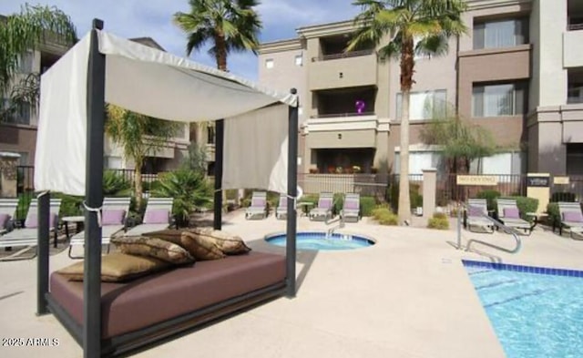 pool featuring a patio, a hot tub, and fence