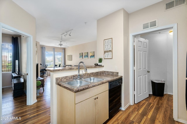 kitchen with a sink, black dishwasher, a peninsula, and visible vents