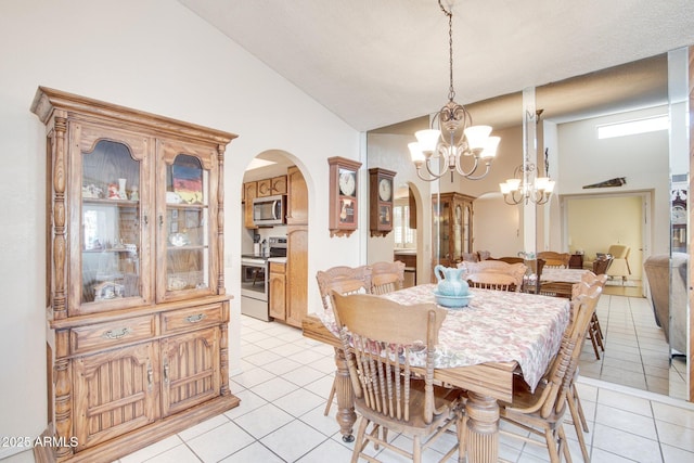 tiled dining space featuring high vaulted ceiling and a chandelier