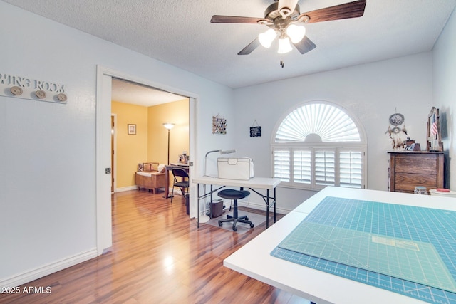 bedroom featuring hardwood / wood-style floors, a textured ceiling, and ceiling fan