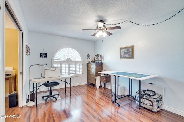 office space featuring hardwood / wood-style flooring, ceiling fan, and a textured ceiling