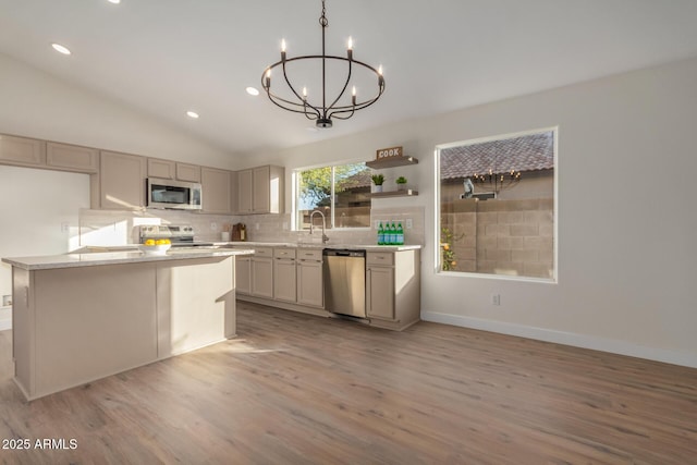 kitchen featuring appliances with stainless steel finishes, light hardwood / wood-style floors, decorative light fixtures, a notable chandelier, and gray cabinets