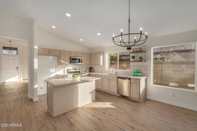 kitchen featuring decorative backsplash, appliances with stainless steel finishes, sink, pendant lighting, and a kitchen island