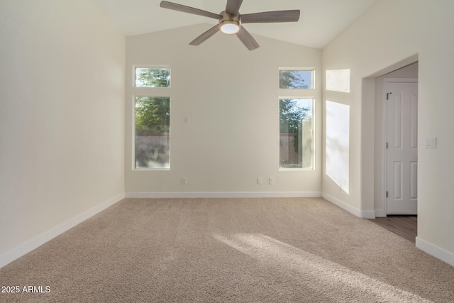 carpeted spare room featuring a wealth of natural light, vaulted ceiling, and ceiling fan