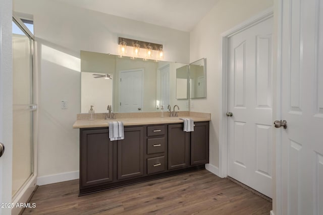 bathroom featuring hardwood / wood-style flooring, ceiling fan, walk in shower, and vanity