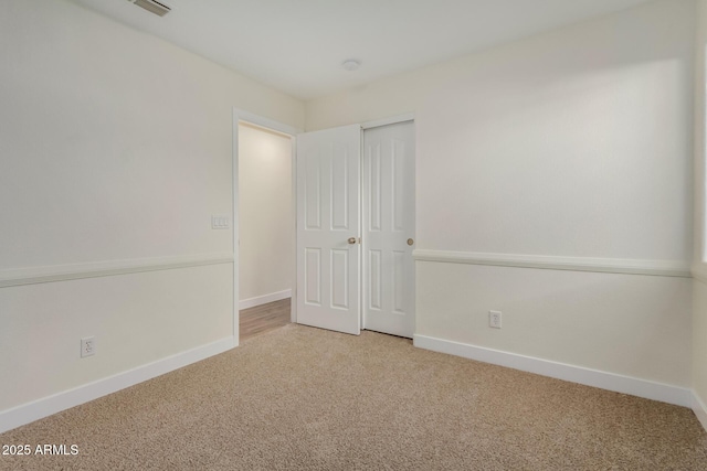 unfurnished room featuring light colored carpet