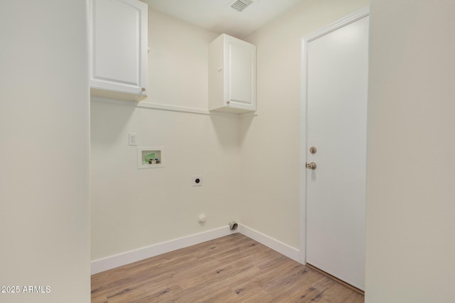 clothes washing area with hookup for an electric dryer, washer hookup, light hardwood / wood-style flooring, and cabinets