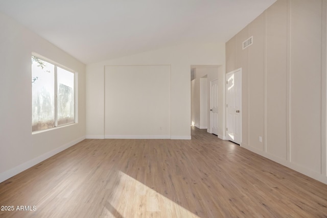 empty room featuring light hardwood / wood-style floors and lofted ceiling