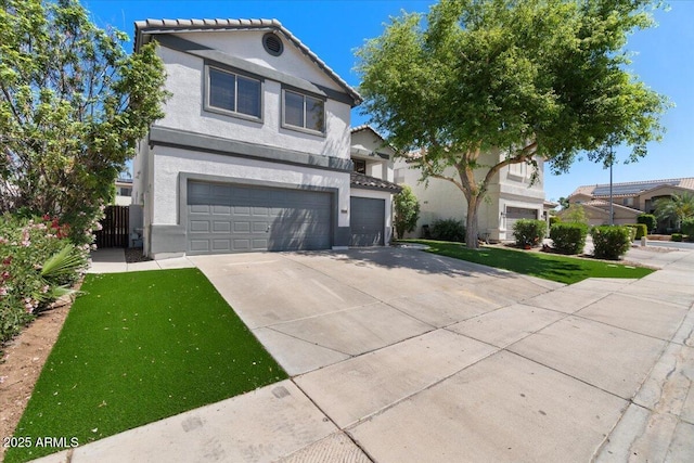 view of front of house featuring a front lawn, stucco siding, an attached garage, driveway, and a tile roof