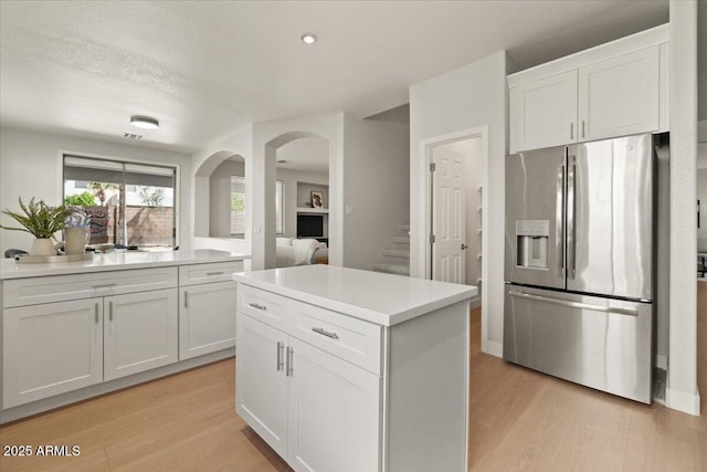 kitchen featuring white cabinetry, light countertops, stainless steel fridge with ice dispenser, recessed lighting, and light wood-style flooring