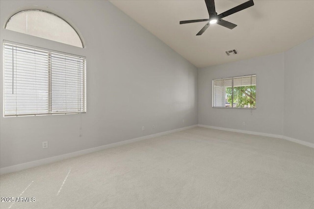 carpeted empty room featuring visible vents, a ceiling fan, baseboards, and lofted ceiling