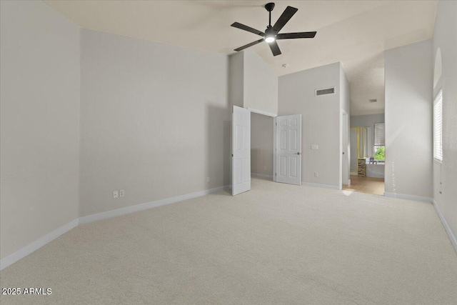 unfurnished bedroom with high vaulted ceiling, baseboards, light carpet, and visible vents