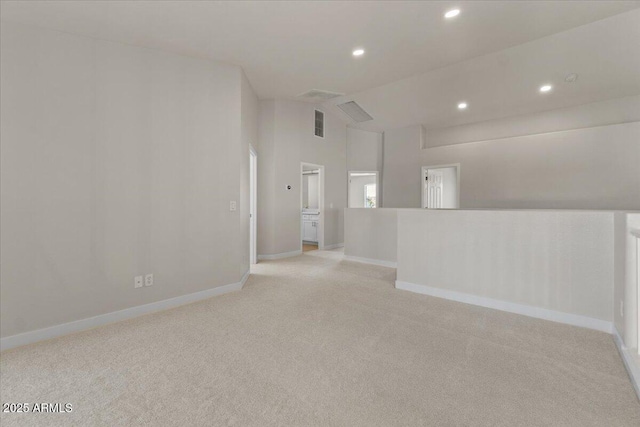 spare room featuring recessed lighting, baseboards, carpet, and lofted ceiling