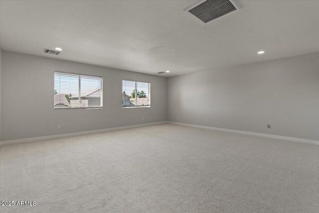 empty room with visible vents, recessed lighting, and light colored carpet