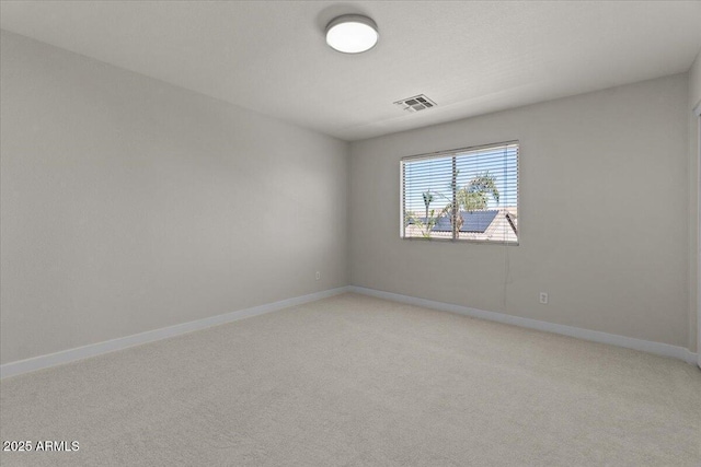 spare room with visible vents, baseboards, and light carpet