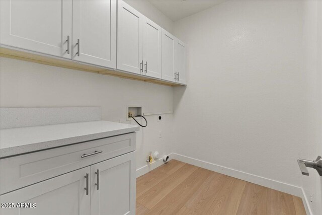 laundry room featuring washer hookup, hookup for an electric dryer, cabinet space, baseboards, and light wood-style floors