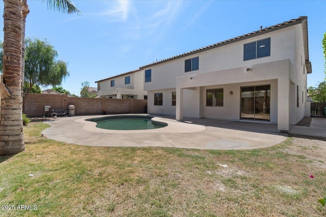 rear view of property with a lawn, a patio area, a fenced in pool, a fenced backyard, and stucco siding