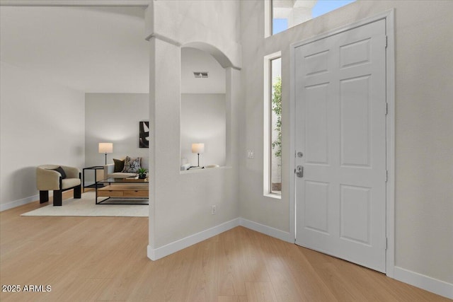 foyer entrance featuring baseboards, light wood-style flooring, and visible vents