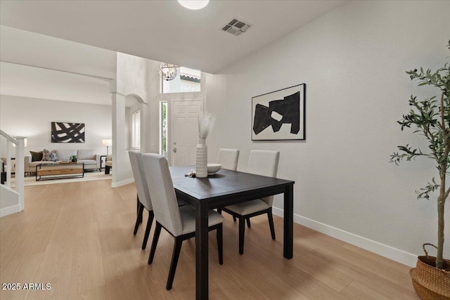 dining room featuring visible vents, light wood-style flooring, baseboards, and an inviting chandelier