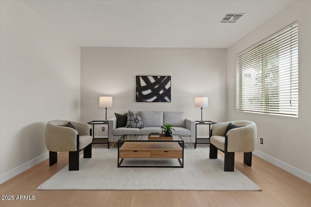 living room featuring baseboards, wood finished floors, and visible vents