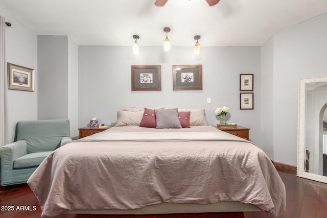 bedroom featuring baseboards, wood finished floors, and a ceiling fan