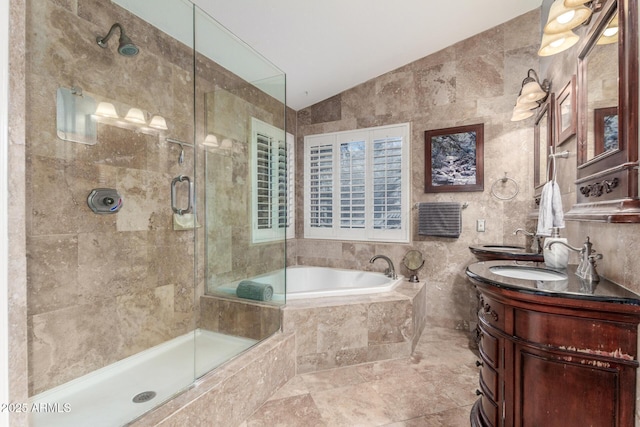 bathroom featuring vaulted ceiling, a tile shower, a bath, tile walls, and a sink