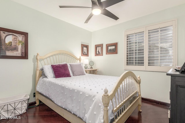 bedroom featuring baseboards, wood finished floors, and a ceiling fan