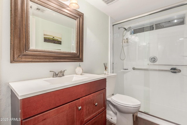 bathroom featuring visible vents, a stall shower, toilet, and vanity